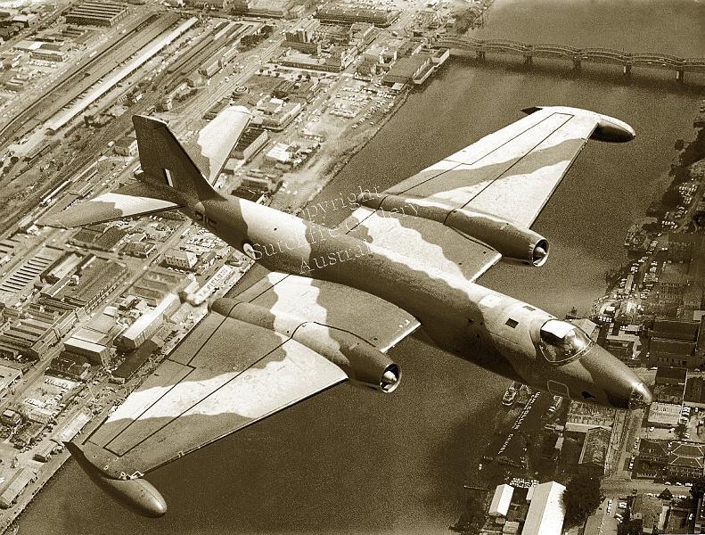 AC41.jpg - Canberra bomber overflying the Brisbane River with the Southbank area below as it was in the late 1960s. Not available in colour.